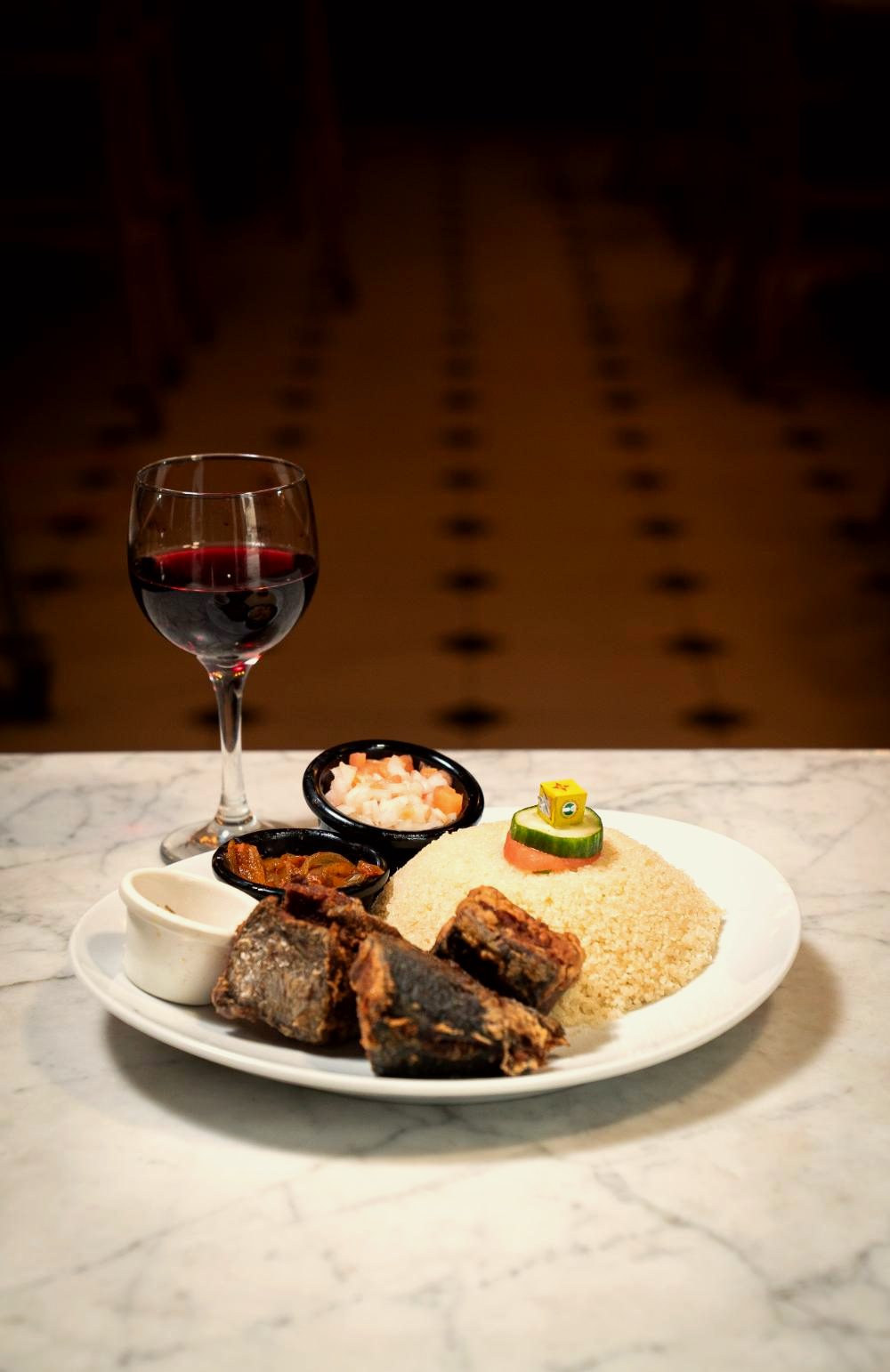 Attiéké, poisson braisé et verre de vin